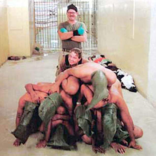 Dos militares sonríen junto a prisioneros apilados y desnudos en un pasillo de la cárcel de Abu Ghraib, que fue un centro de torturas de Sadam Husein y utilizada luego de la invasión estadounidense como centro de detención y torturas contra supuestos terroristas. La imagen, que primero fue ofrecida por la cadena CBS, fue cedida después por ‘The New Yorker’ a la agencia Reuters. (Reuters)