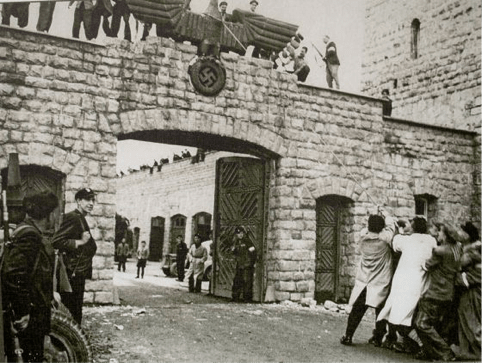 Un grupo de prisioneros derriba el símbolo nazi instalado en la entrada del campo de Mauthausen, el día de la liberación. Francesc Boix, 5 de mayo de 1945. Fondo Amical Mauthausen/Museu d’Història de Catalunya.
