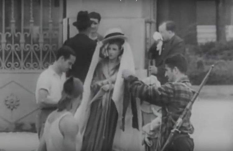 Unos milicianos engalanan una figura religiosa antes de prender fuego a la pira que corona. Escena del documental anarquista Movimiento Revolucionario en Barcelona, Mateo Santos, 1936.